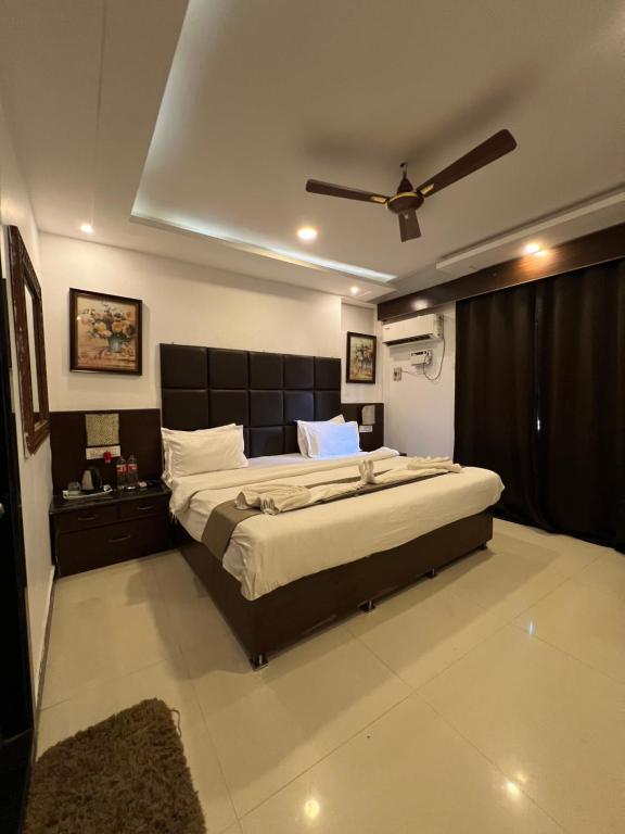 ein Schlafzimmer mit einem großen Bett und einem Deckenventilator in der Unterkunft Sportsman Beach Hotel in Calangute