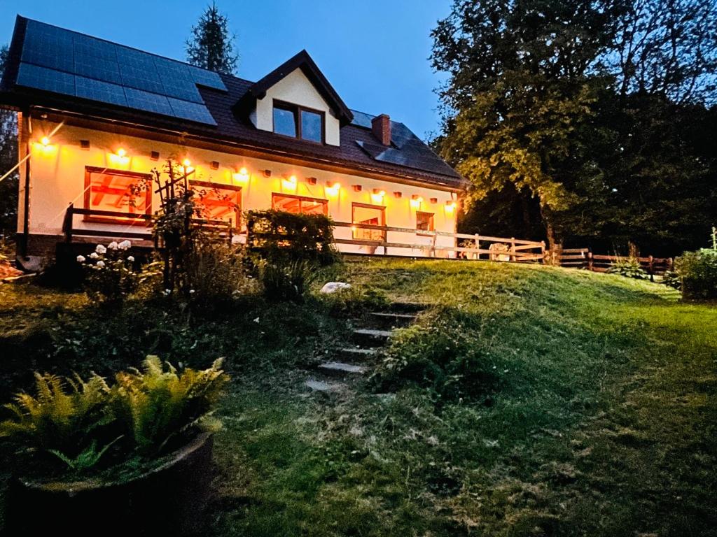 a house with lights on the side of a yard at Park Wilkasy in Gołdap