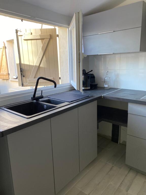a kitchen with a sink and a counter top at Studio à la campagne in La Tour-dʼAigues