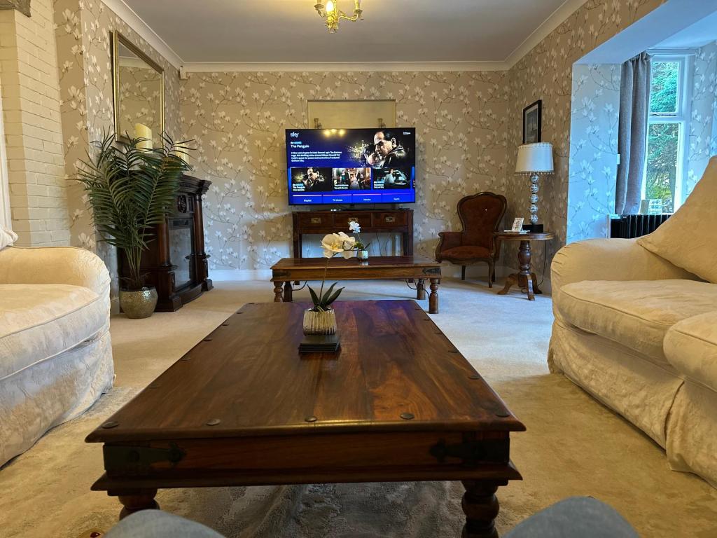 a living room with a coffee table and a flat screen tv at The Old Vicarage in Berwick-Upon-Tweed