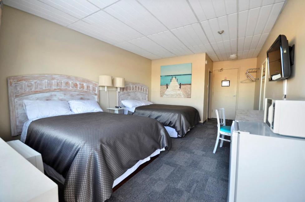 a hotel room with two beds and a table at St. Norbert Hotel in Winnipeg