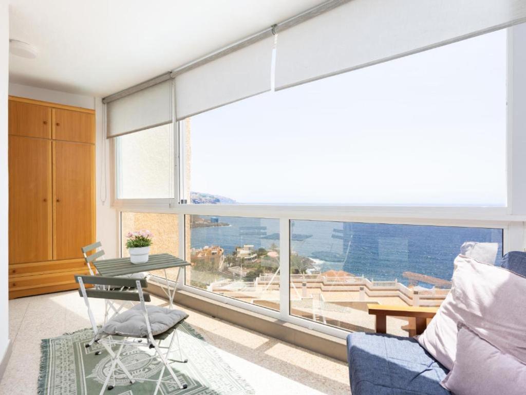 a living room with a blue couch and a large window at Live Candelaria Tamonante in Candelaria