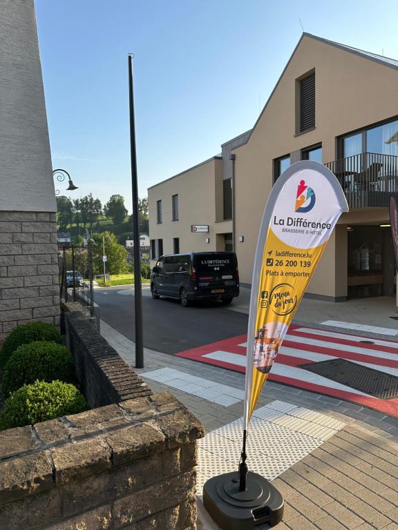 a sign on a sidewalk in front of a building at La Différence in Vichten