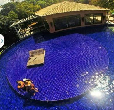 a large purple table with two figurines on top of it at Bangalô Villas do Pratagy com jacuzzi in Maceió