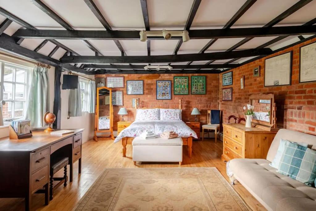 une chambre avec un lit et un mur de briques dans l'établissement Cozy One-Bedroom Cottage in Great Tey, à Great Tey