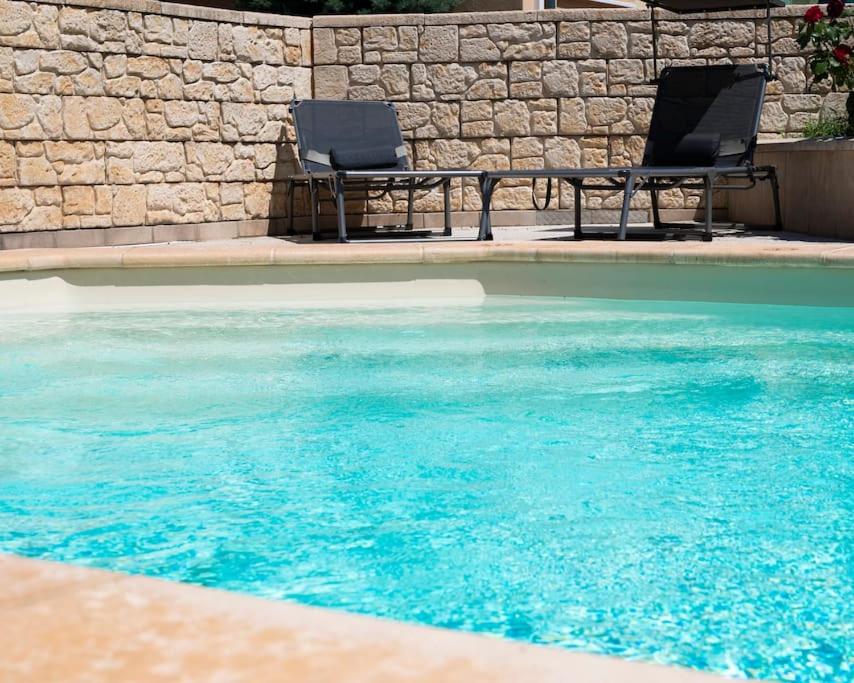 two chairs sitting next to a swimming pool at Villa La Perle Bleue in Ebersheim