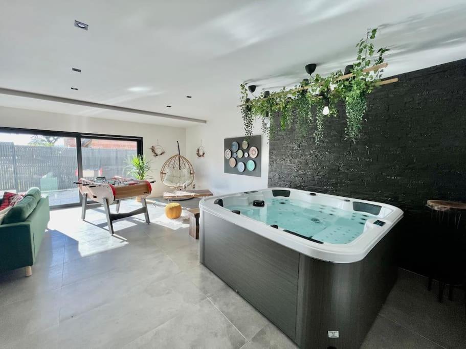 a living room with a large tub in the middle at Magnifique villa avec jacuzzi in Bourgheim