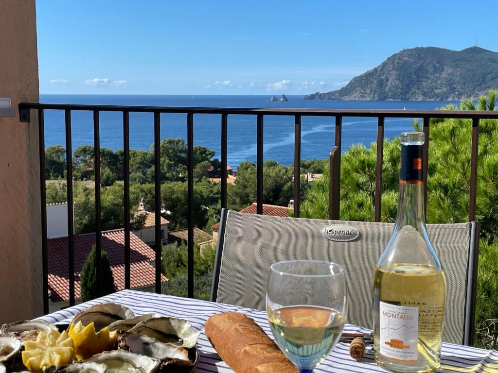 - une table avec une bouteille de vin et un verre dans l'établissement Les 2 frères - Vue mer panoramique solarium - les Sablettes, à Saint-Mandrier-sur-Mer