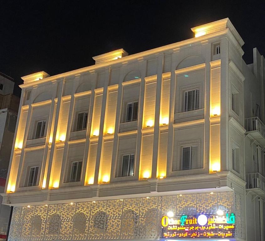 a large white building with lights on it at night at سماء البوادي للشقق المفروشة in Jeddah