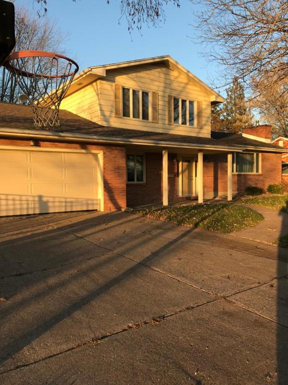 a house with a basketball hoop in the driveway at Family friendly spacious with jacuzzi & fireplace! in Dubuque