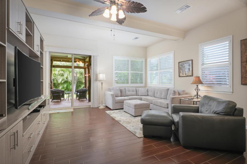 Una sala de estar con un sofá y un televisor. en Fairways at Mauna Lani 1405 Garden View 3B 2 and half Bath, en Waikoloa