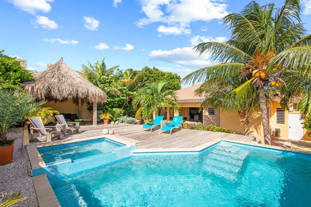 a swimming pool with chairs and a house at Villa Rubio, Luxury Private Villa in Grote Berg, Curaçao in Grote Berg