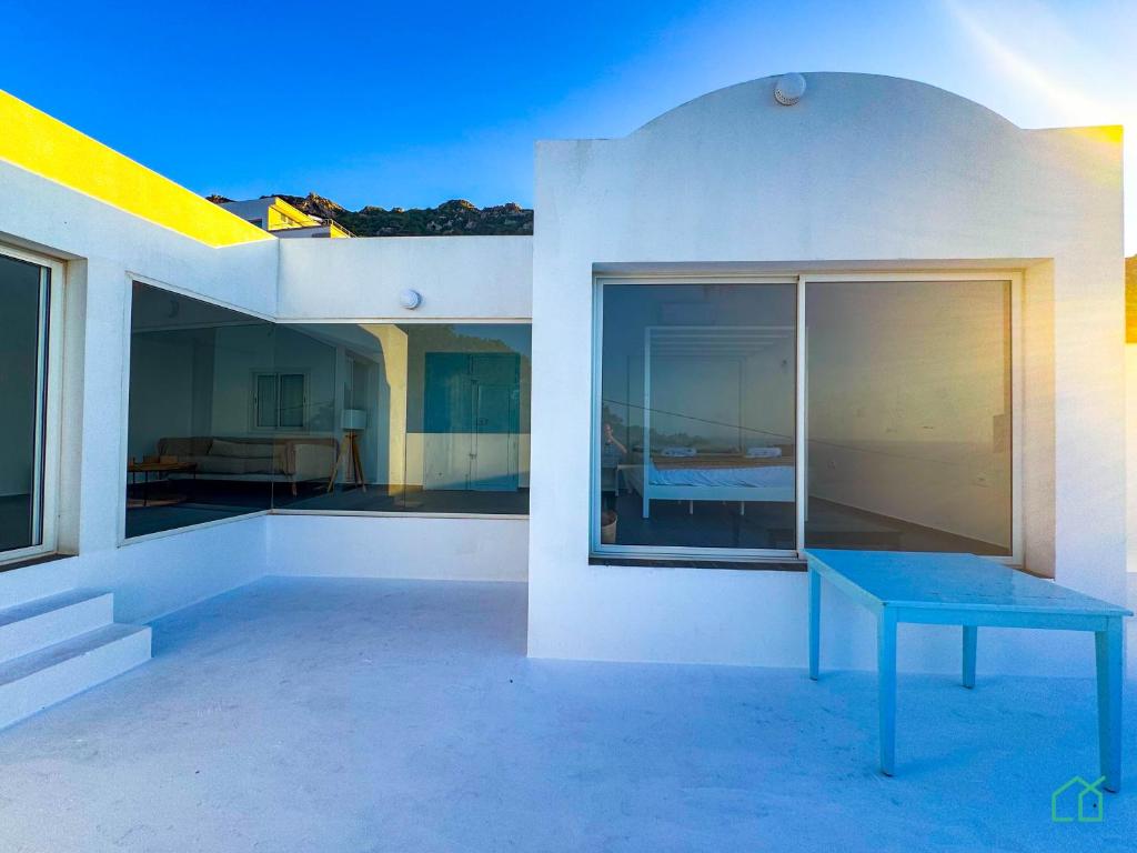 Una casa con una mesa azul a un lado. en Padel Resort: 2bd Apt with panoramic view, en Rafrāf