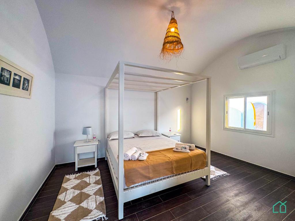 1 dormitorio con cama con dosel en una habitación en Padel Resort: 2bd Apt with panoramic view, en Rafrāf