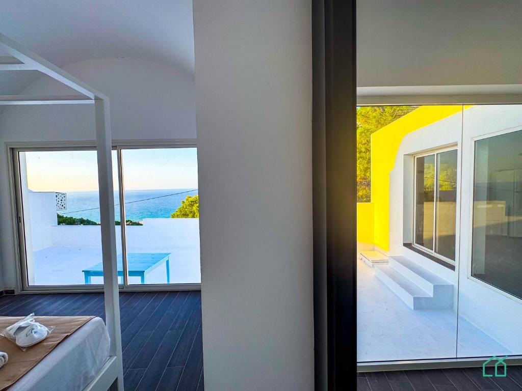 Habitación con balcón y vistas a una casa. en Padel Resort: 2bd Apt with panoramic view, en Rafrāf