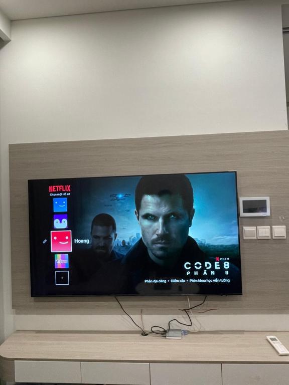 TV de pantalla plana en la parte superior de una pared en Masterise Vin, en Phú Thú