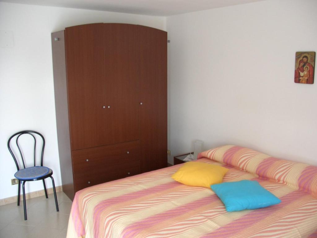 1 dormitorio con 1 cama, armario y silla en B&B Il Sogno, en Montescaglioso