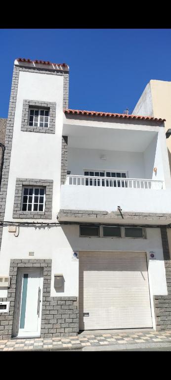 a white building with a garage in front of it at Casa Esperanza in Arinaga