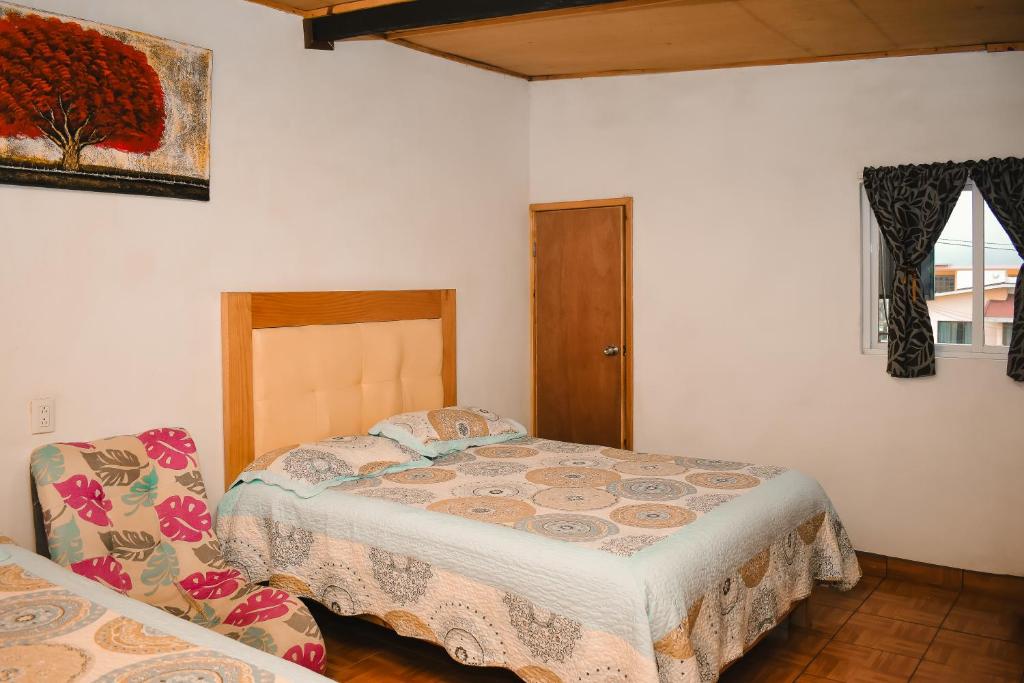 a bedroom with a bed and a chair at CABAÑA tipo habitación planta alta en Zacatlàn in Zacatlán