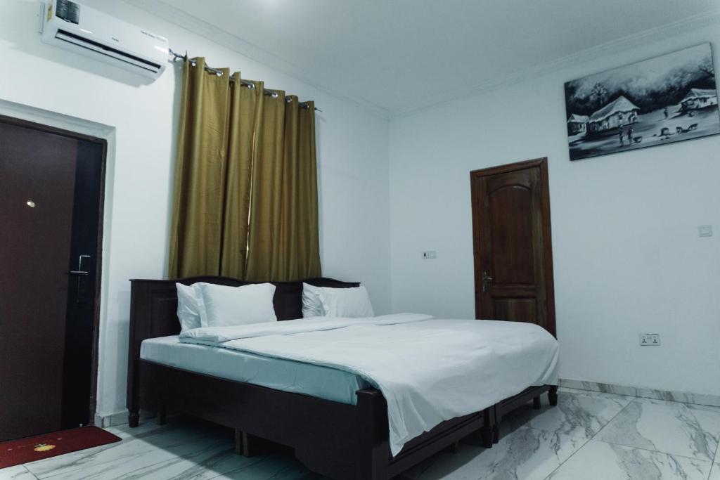 a bedroom with a bed in a room at Ragant Hotel in Kwapro