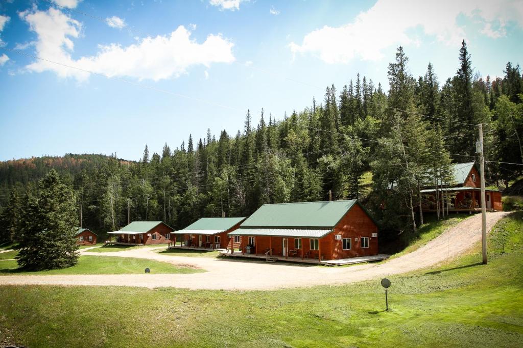 a large red building in the middle of a forest at Cole Cabins in Deadwood