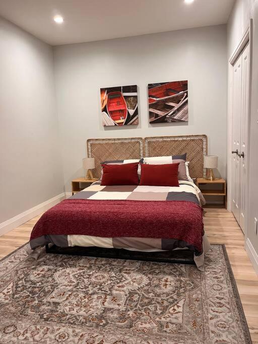 a bedroom with a bed with red pillows on it at Stylish 3-bdrm suite w free Parking in Kitchener