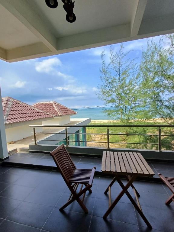 a porch with a bench and a view of the ocean at Mengkuang Villa - Deluxe Room in Penarek