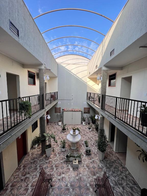 a large building with a ceiling with a table and chairs at Pousada Golden House - Próxima ao Thermas no Centro de Aguas in Águas de São Pedro