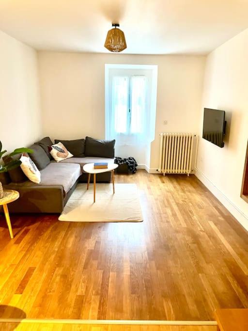 un salon avec un canapé et une table dans l'établissement Maison à 7 min de Dijon, à Ruffey-lès-Échirey