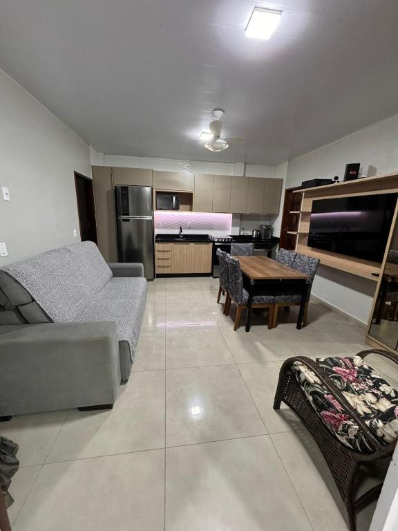 a living room with a couch and a table at casa canasvieiras 100 m praia in Florianópolis
