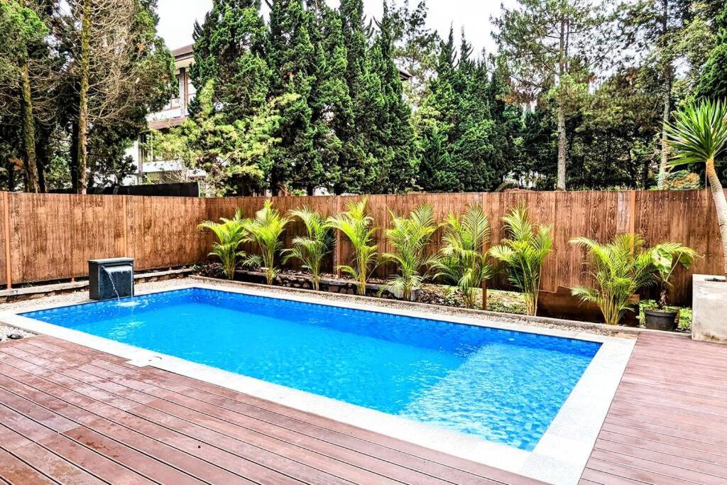 - une piscine dans un jardin avec une clôture en bois dans l'établissement Cottonwood Villa Rotensia BBQ Pool Pingpong, à Bandung