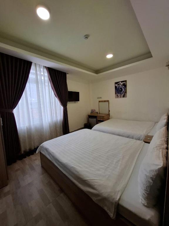 Postel nebo postele na pokoji v ubytování Vanilla Dalat Hotel