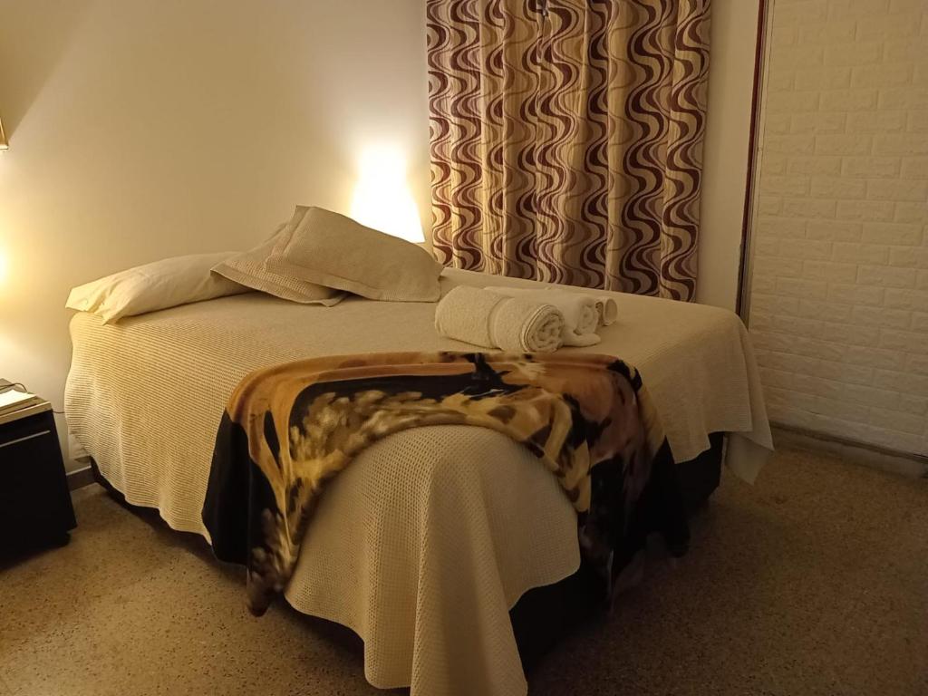 - une chambre avec un lit et une table avec des serviettes dans l'établissement Corrientes Grand Apart, à Corrientes