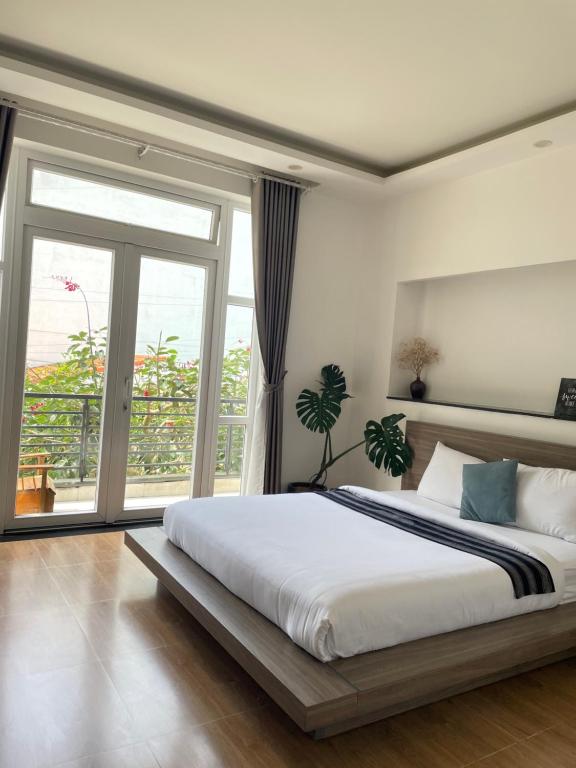 a bedroom with a large bed and a large window at K HO DISCOVERY Guest House in Da Lat