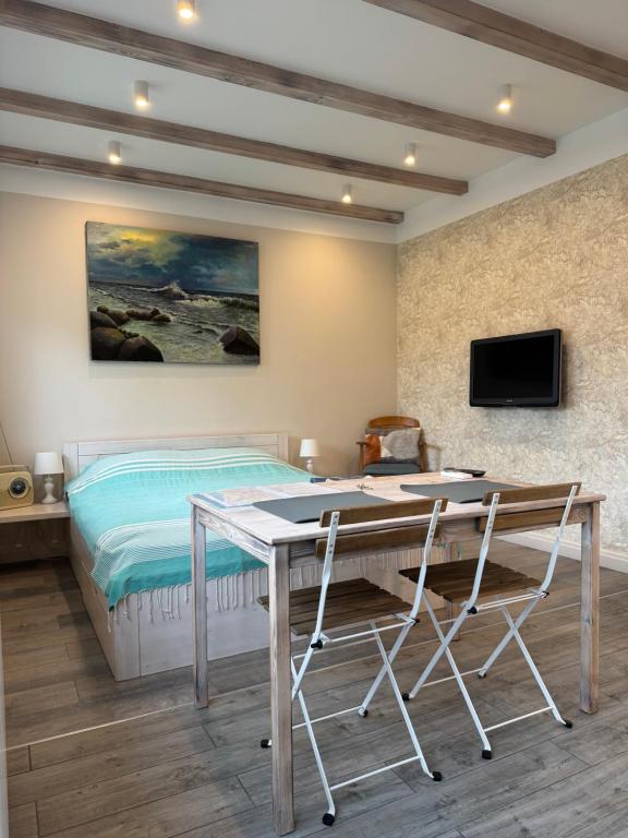 a bedroom with a bed and a desk with two chairs at Old Center Apartment in Liepāja
