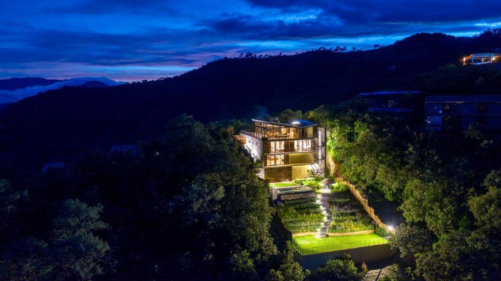 an aerial view of a mansion in the woods at night at Espectacular casa con hermosa vista al lago - El Santuario Resort in Colorines