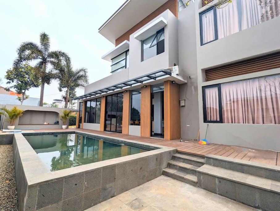 une maison avec une piscine devant dans l'établissement Cottonwood Villa Zamrud - Pingpong BBQ Pool Disney, à Tegalharendong