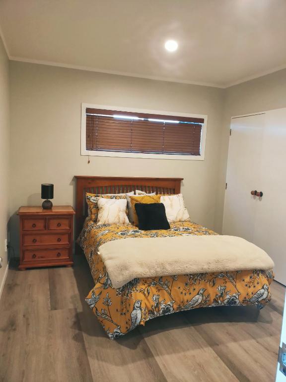 una camera da letto con un letto, un comò e una finestra di Lakaz a Omokoroa