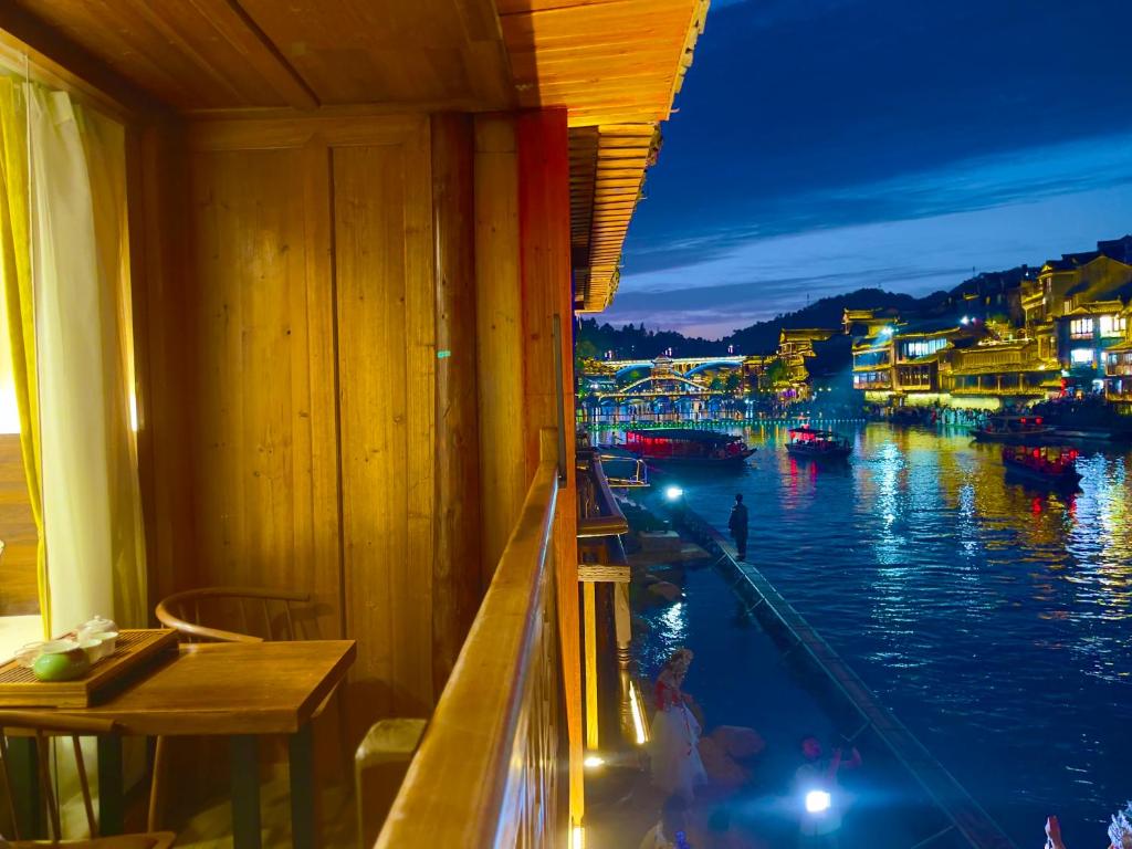 a room with a view of a river at night at Bian Cheng Xing Zi Inn in Fenghuang County