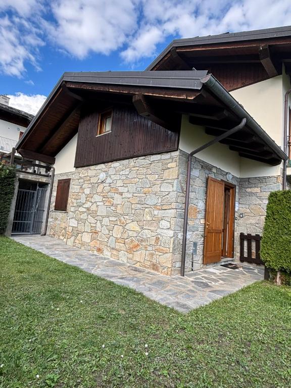 a stone building with a wooden door on it at Villetta con giardino in Doues