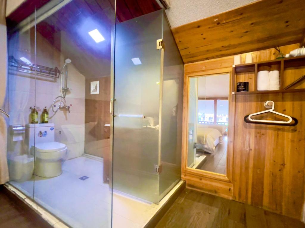 a bathroom with a shower and a toilet at Bian Cheng Xing Zi Inn in Fenghuang County