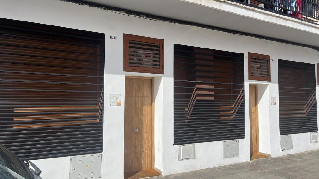 a building with three garage doors on the side of it at Califa SuitesGP in Córdoba