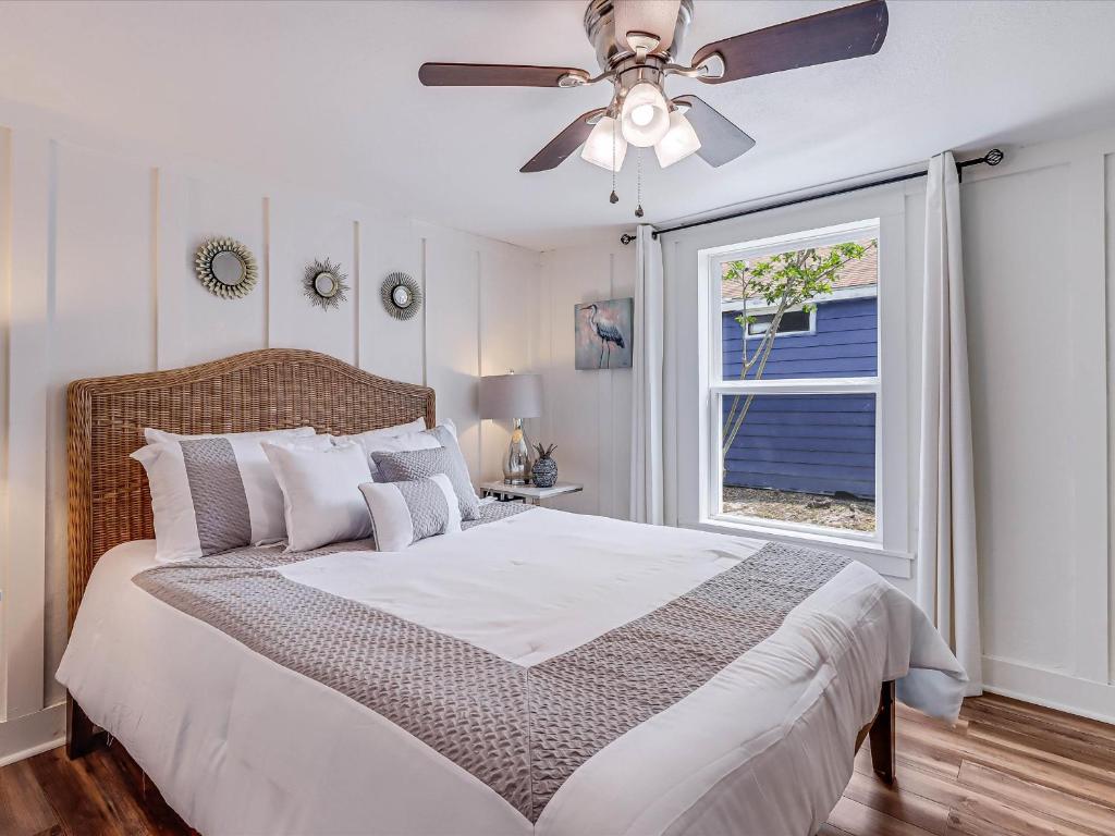 Un dormitorio con una cama con ventilador de techo y una ventana. en Bahia OZ RP105, en Rockport