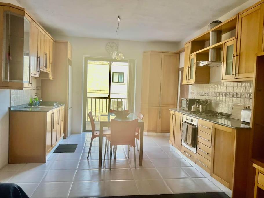 a kitchen with a table and chairs in it at Spacious 3 bedroom in Swatar - Birkirkara in Birkirkara