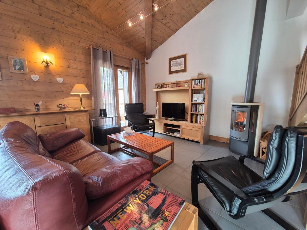 un salon avec un canapé en cuir et une cheminée dans l'établissement Grand Coeur C13 - Appartement-chalet au cœur de Bourg-Saint-Maurice, à Bourg-Saint-Maurice