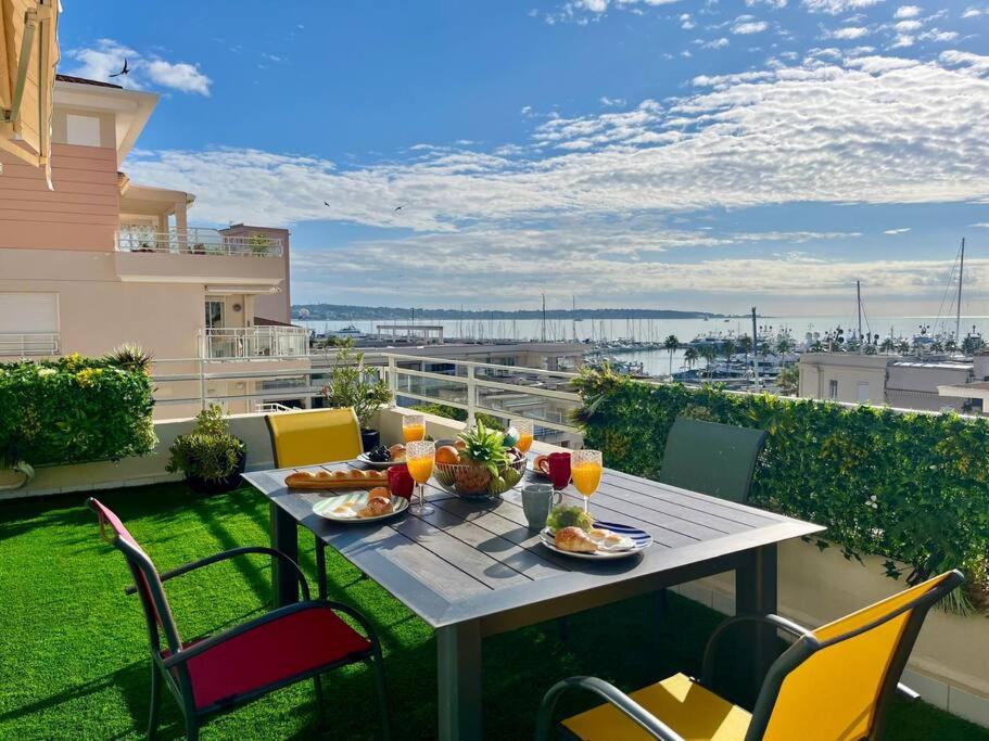 une table avec de la nourriture et des boissons sur un balcon dans l'établissement Azur Riviera YourHostHelper, à Vallauris
