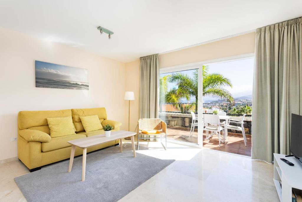 ein Wohnzimmer mit einem gelben Sofa und Meerblick in der Unterkunft El Estanque - Vivienda vacacional in Puerto de la Cruz