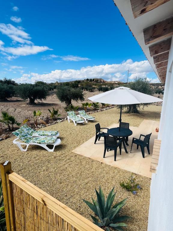 a patio with a table and chairs and an umbrella at RenBeck lets 2 in Urcal