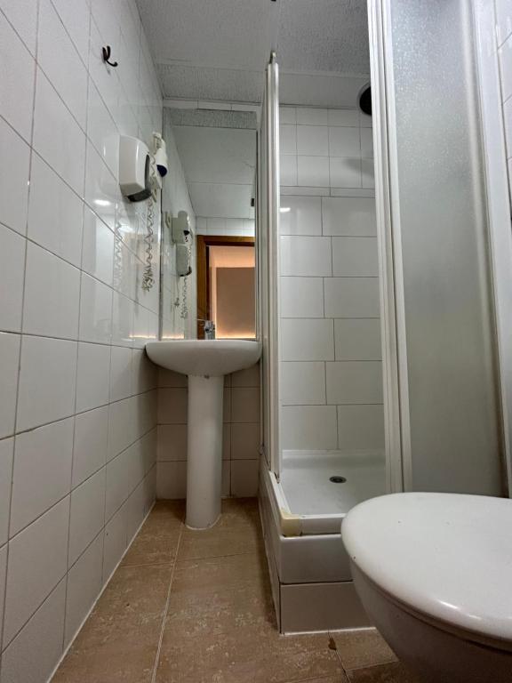 a bathroom with a shower and a sink and a toilet at H21 Rooms in Madrid