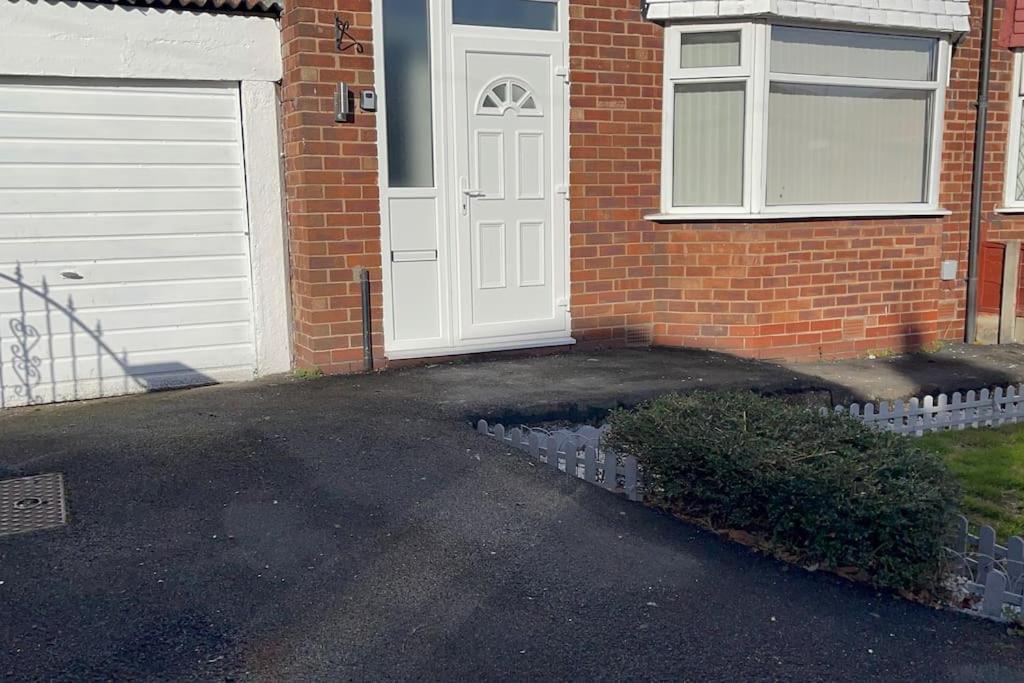 Una puerta blanca de una casa de ladrillo con garaje. en House of Peace & Rest, en Mánchester